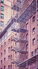 Fototapeta premium Vintage toned photo of a residential building fire escape in Manhattan, New York City, USA.