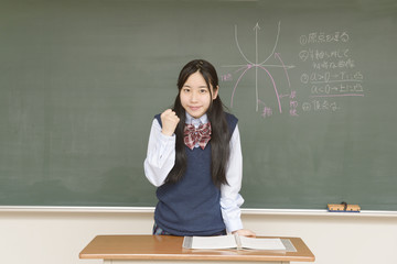黒板に数式を書く女子高生