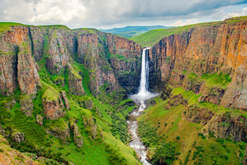 Maletsunyane Falls in Lesotho Africa. Most beautiful waterfall in the world. Green scenic landscape of amazing water fall dropping into a river inside canyons. Panoramic views over the great falls.