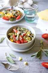 Pasta tagliatelle with fried sage and tomatoes. Top View Served Table

