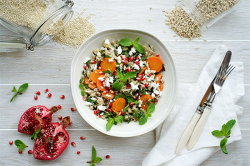 Carrot salad with a mixture of grains, mint and pomegranate. The concept of healthy,  seasonal food...