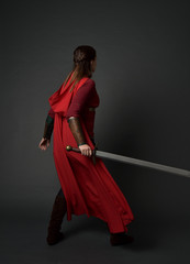 full length portrait of brunette girl wearing red medieval costume and cloak. standing pose  with...