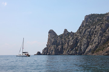 View to rock behind the sea with  fishing boat in waves