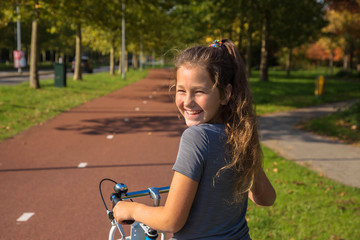 Happy child rides a bike on bike path.