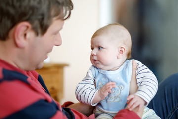 Happy proud young father with newborn baby daughter, family portrait togehter