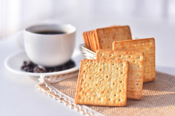 Biscuits with cup of coffee background in morning light