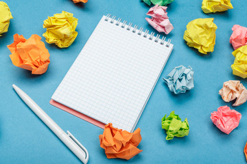 Office workspace with an empty notebook, crumpled paper