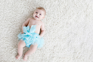 Adorable baby girl on white background wearing turquoise tutu skirt. © Irina Schmidt