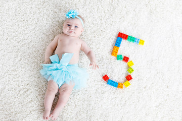 Adorable baby girl on white background wearing turquoise tutu skirt. © Irina Schmidt