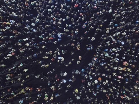 An Aerial Shot Of The People Gathered For An Event. Crowed Open-air Meeting Of People Shot From A Height. A Mass Of People Gathered To Celebrate An Event. Open-air Night Festival. City Merrymaking.