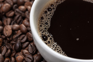 Cup of coffee and beans on wooden background