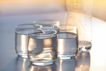 Drinking water in clear glasses against the morning sunlight