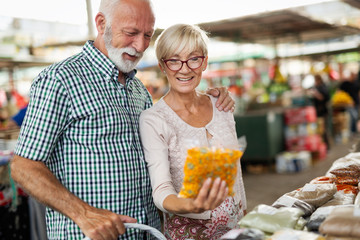 Beautiful senior couple choosing health products in the market