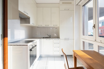 Front view modern kitchen with wooden table and window