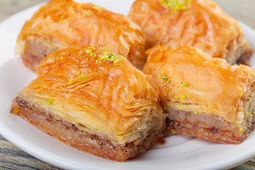 Traditional arabic dessert baklava with cashew, walnuts and cardamom with an eucalyptus branch on a wooden table