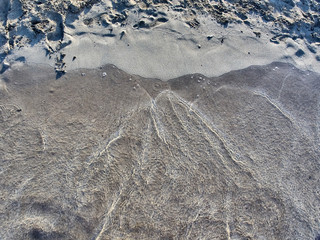 Shot of the waves on sand at the beautiful tropical San Lorenzo beach near Syracuse in a sunny day of summer