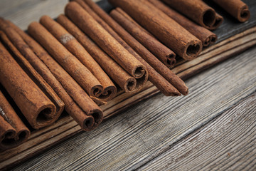 Cinnamon sticks on wooden background.