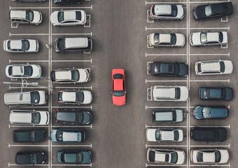 Top view of the crowded Parking lot with quadcopter or drone. Original bright automobile among the grey of mediocre cars. Parking space search, No parking space