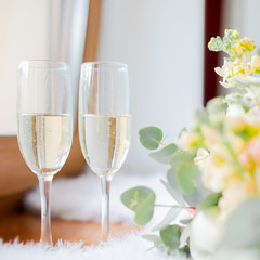 Wedding morning, two glasses of champagne and bride's bouquet of peony and roses.