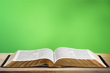 Open book on old wooden table.