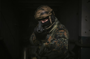 A army soldier takes aim with a rifle in his hands to the screen. Storming the building concept. Front view.