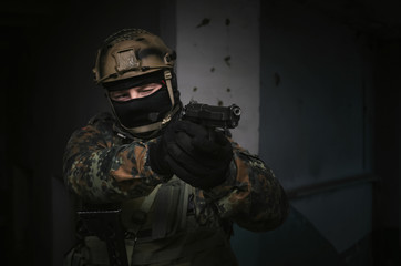 A army soldier takes aim with a pistol gun in his hands. Storming the building concept.