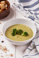 Creamy broccoli soup in a white bowl. Healthy food