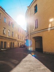 Parts of yellow round houses with sun glare against the blue clear sky in St. Petersburg