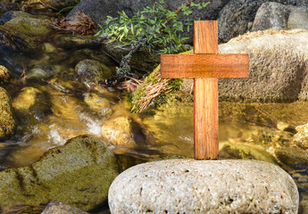 Wooden Cross on a rock on rocks basckground