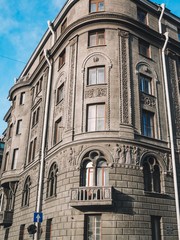 Fototapeta premium The facade of the historic old building with sculptures is against the background of blue clear sky in St. Petersburg
