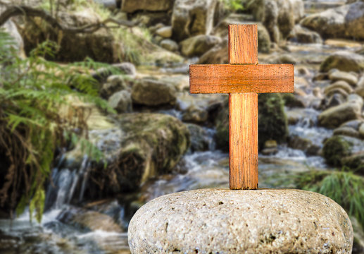 Wooden Cross on a rock with river background