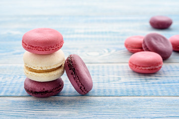 Sweet macarons on a blue  background. Trendy cakes.