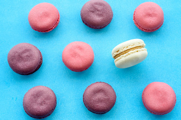 Sweet macarons on a blue  background. Trendy cakes.