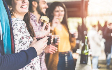 Happy friends drinking wine and eating at barbecue dinner outdoor