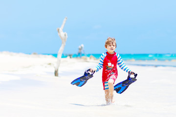 little blond kid boy having fun on tropical beach of Maldives