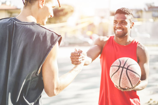 Happy athletes friends playing basketball outdoor in city urban contest - Young people shakings hands in mark of respect - Youth, healthy lifestyle and friendship concept - Focus on fingers