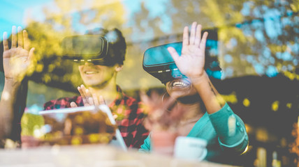 Happy friends using virtual reality goggles in modern coworking space