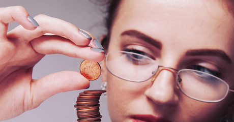 Beautiful business woman with column coins as symbol of investment or growth. (Money, wealth,...