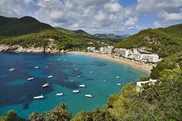 Obraz premium Rajska plaża na wyspie Ibiza z błękitnym niebem i krystalicznie czystą wodą