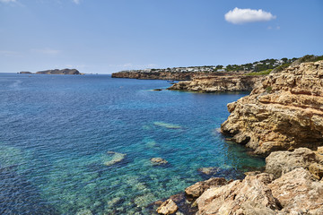 View of beautiful beach in Cala Salada bay famous for its azure crystal clear sea water, Ibiza island, Spain