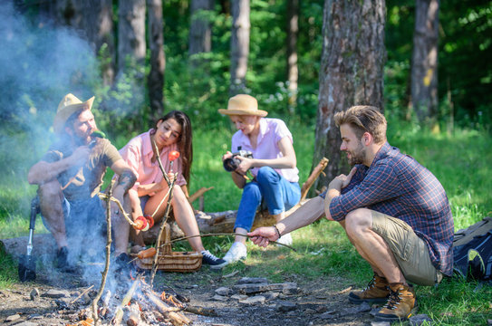 Company having hike picnic nature background. Summer hike. Hikers sharing impression of walk and eating. Picnic with friends in forest near bonfire. Tourists with camera relaxing checking photos