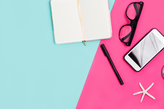 Close up office desk with stationery, glasses and smartphone