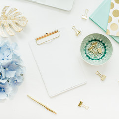 Modern home office desk workspace with blank paper clipboard, hydrangea flower bouquet on white...