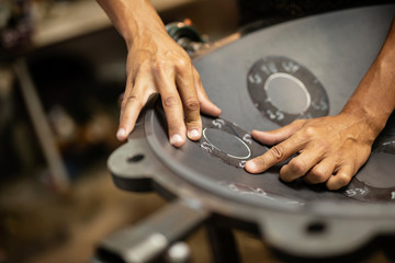 Hands designing handpan in a workshop