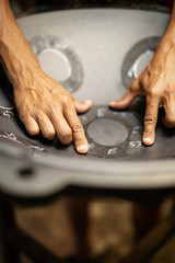 Hands designing handpan in a workshop
