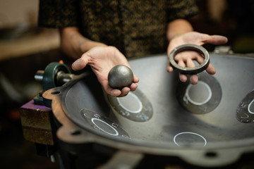 Hands designing handpan in a workshop