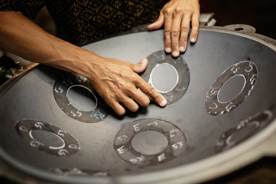 Hands designing handpan in a workshop