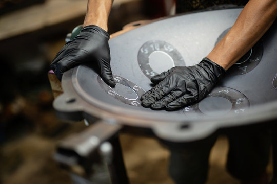 Hands designing handpan in a workshop