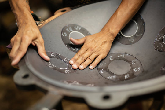 Hands designing handpan in a workshop