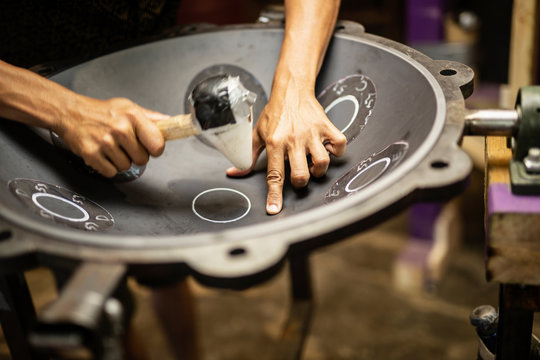 Hands designing handpan in a workshop